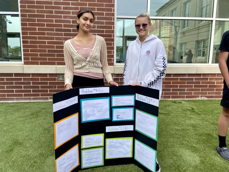 Cora Halfter, left, and Mina Swier share their work with classmates.